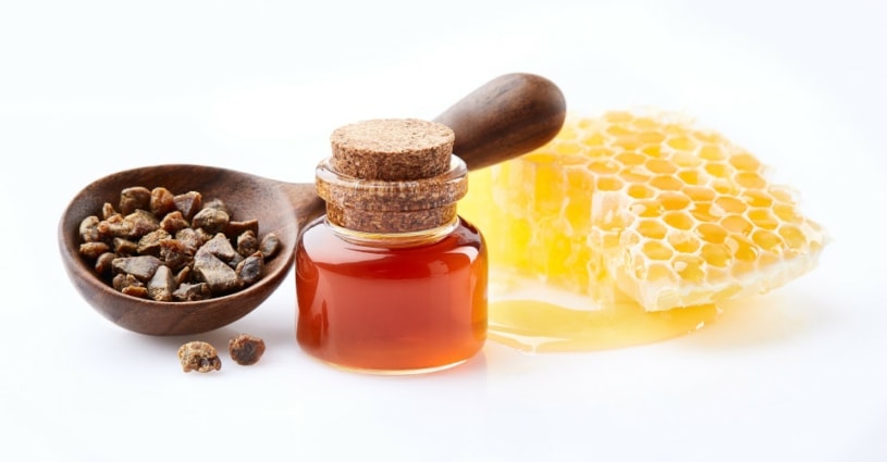 Rohpropolis, Propolistinktur und Bienenwabe mit Honig auf weißem Hintergrund